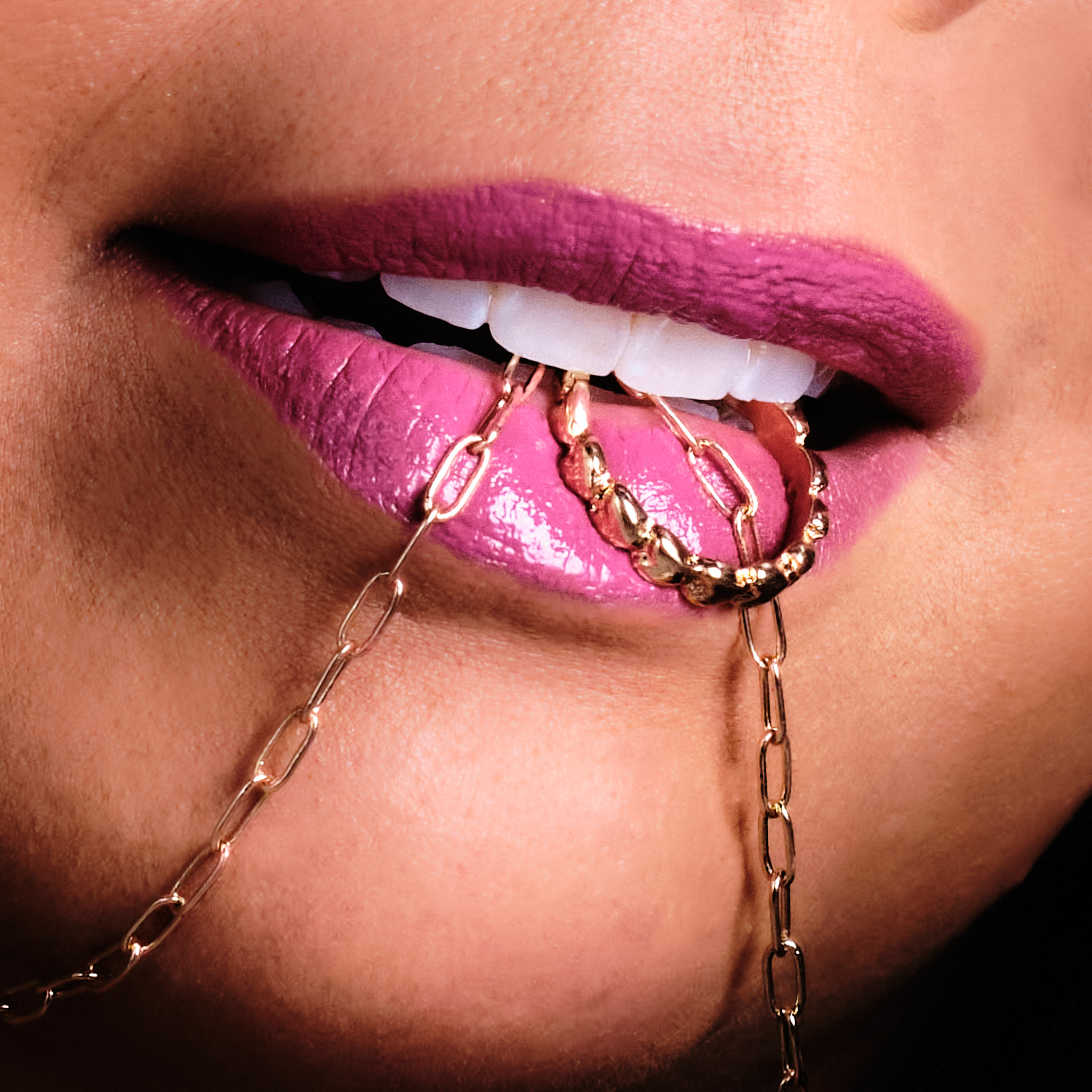 Lip - close up of model biting on a paperclip link chain.
