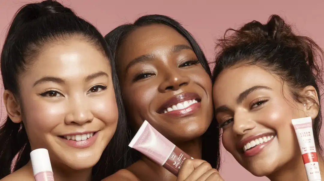 Three women smiling holding CoverGirl products